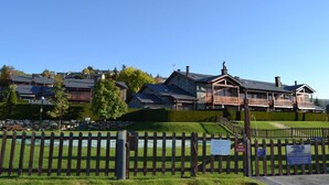 A residential area with houses, a wooden fence, and a clear sky.
