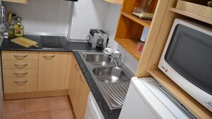 Une petite cuisine équipée d’un évier, d’un grille-pain et d’un four à micro-ondes.