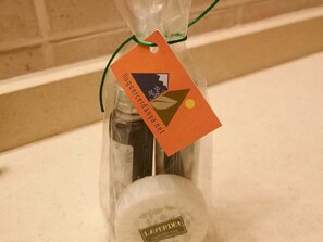 A bottle with a tag in a plastic bag on a countertop.