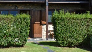 A stone building with a wooden door and a balcony. - Apartment 3 rooms Fireplace, Private Garden & Cadí Views (Ger)