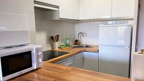 A modern kitchen with white cabinets, a built-in microwave, a sink, and a refrigerator. - Duplex 2 rooms 6 Pax, Fireplace, Views, Dishwasher & Washer (Bourg-Madame)