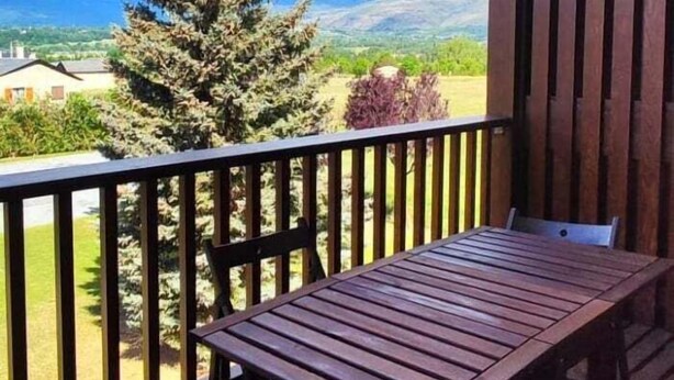 A wooden deck with a table and chairs, overlooking a landscape with trees and buildings. - Duplex 2 rooms 6 Pax, Fireplace, Views, Dishwasher & Washer (Bourg-Madame)