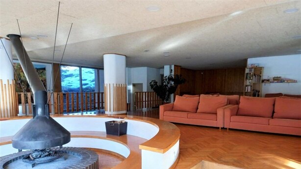 A modern living room with a fireplace, wooden flooring, a sofa, and a staircase. - Duplex 3 Bed Parking, Ski Storage & Games Room (La Molina)