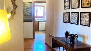 Una habitación con una mesa de madera, una máquina de coser y un espejo con un marco decorativo.