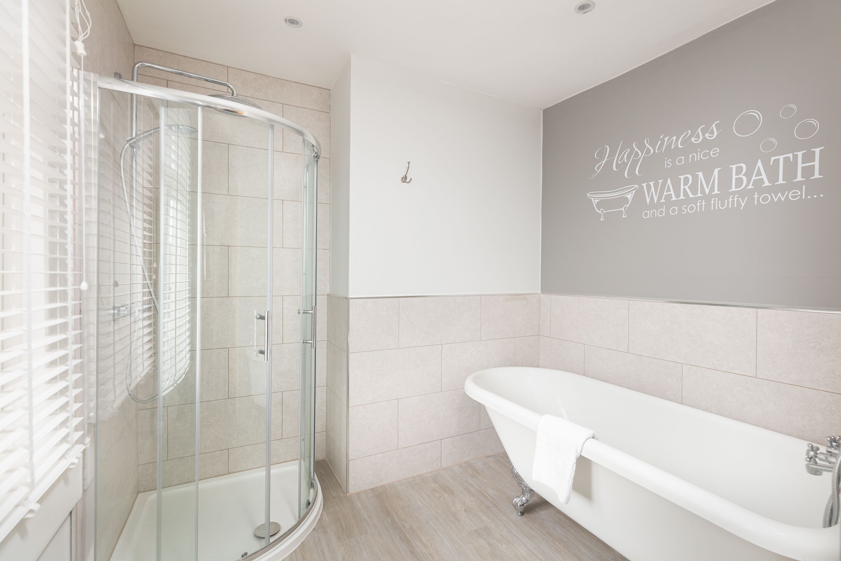 A modern bathroom with a glass-enclosed shower, a freestanding bathtub, and a wall-mounted towel rack.