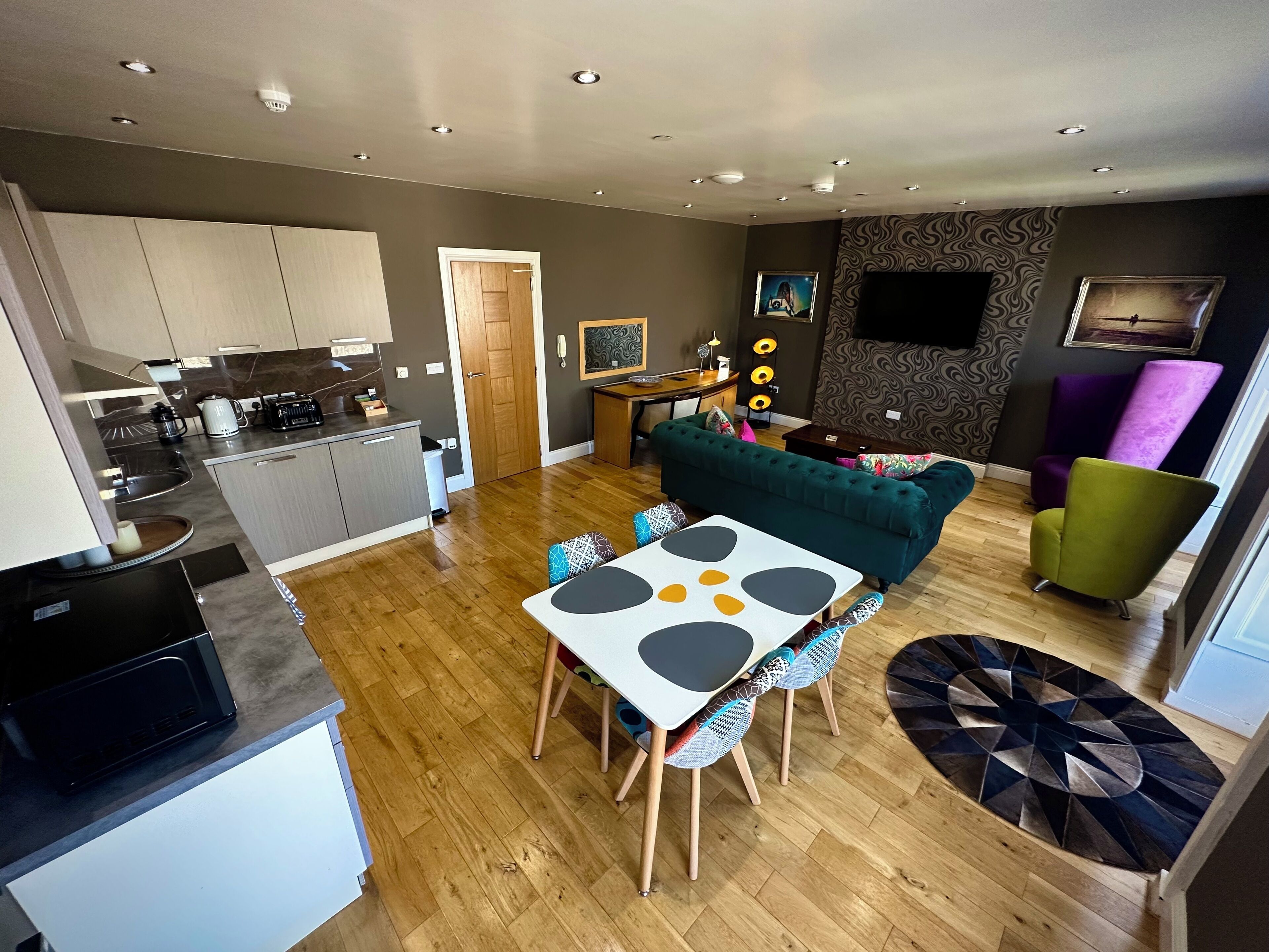 A modern apartment with a kitchen, dining area, and living room.