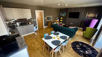 A modern apartment with a kitchen, dining area, and living room.