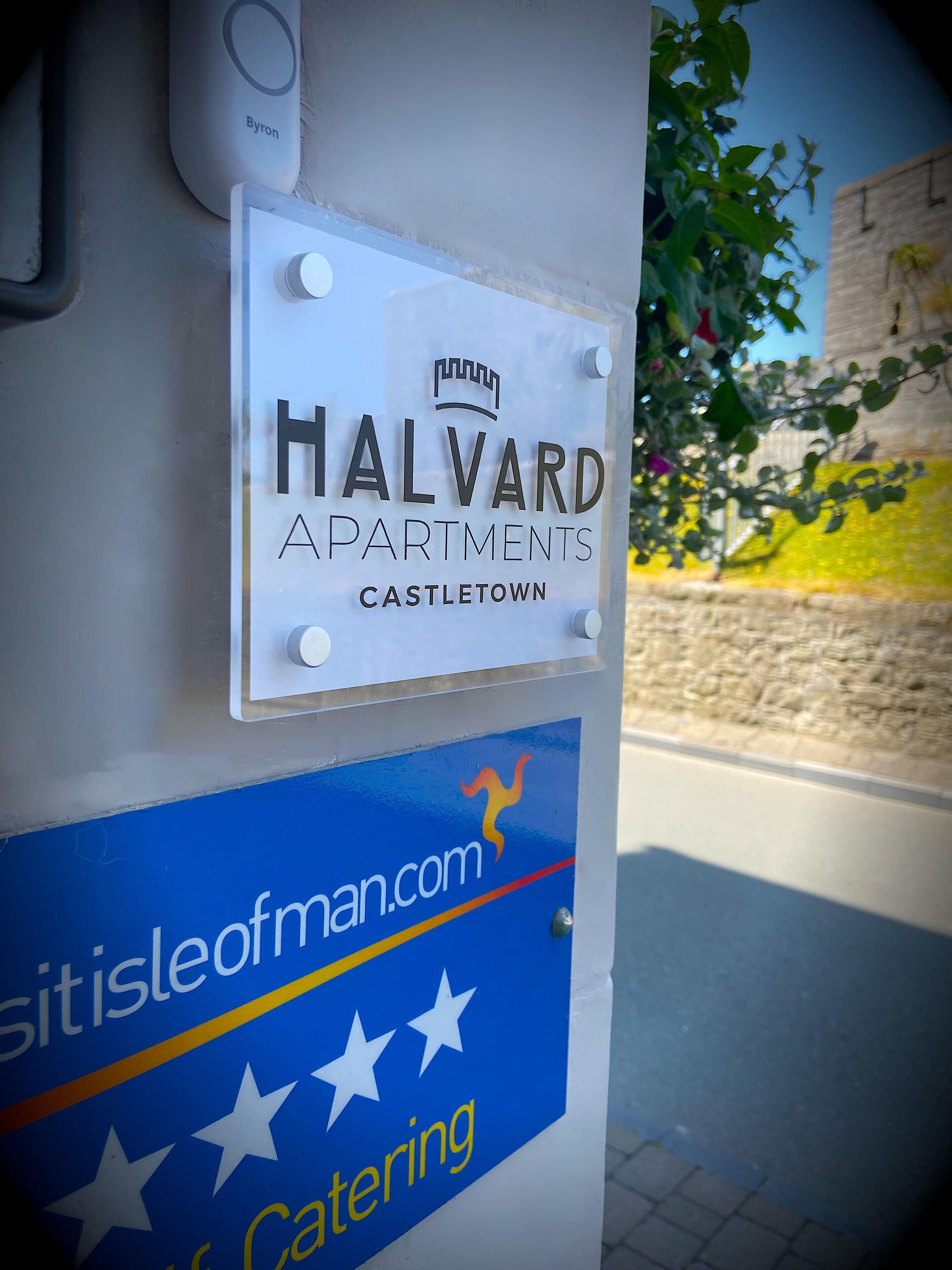A sign for Halvard Apartments in Castle Town, featuring a website link and a catering service.