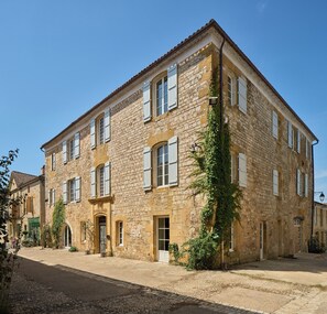 Traditional architecture meets charming charm in this two-story building with a central entrance and picturesque garden.