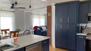 A modern kitchen with dark cabinets, a dishwasher, and a coffee maker. - Ocean View cottage in Indian Neck. Super Host with 5-Star Rating (Branford)
