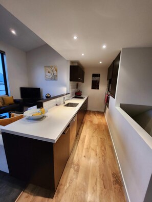 A modern kitchen with a central island, a built-in oven, and a microwave.