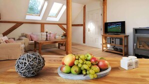 Un salon chaleureux avec une table en bois, un téléviseur et une cheminée.