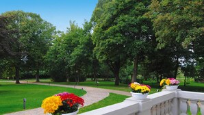 Un jardin avec un chemin pavé et des jardinières blanches ornées de fleurs.