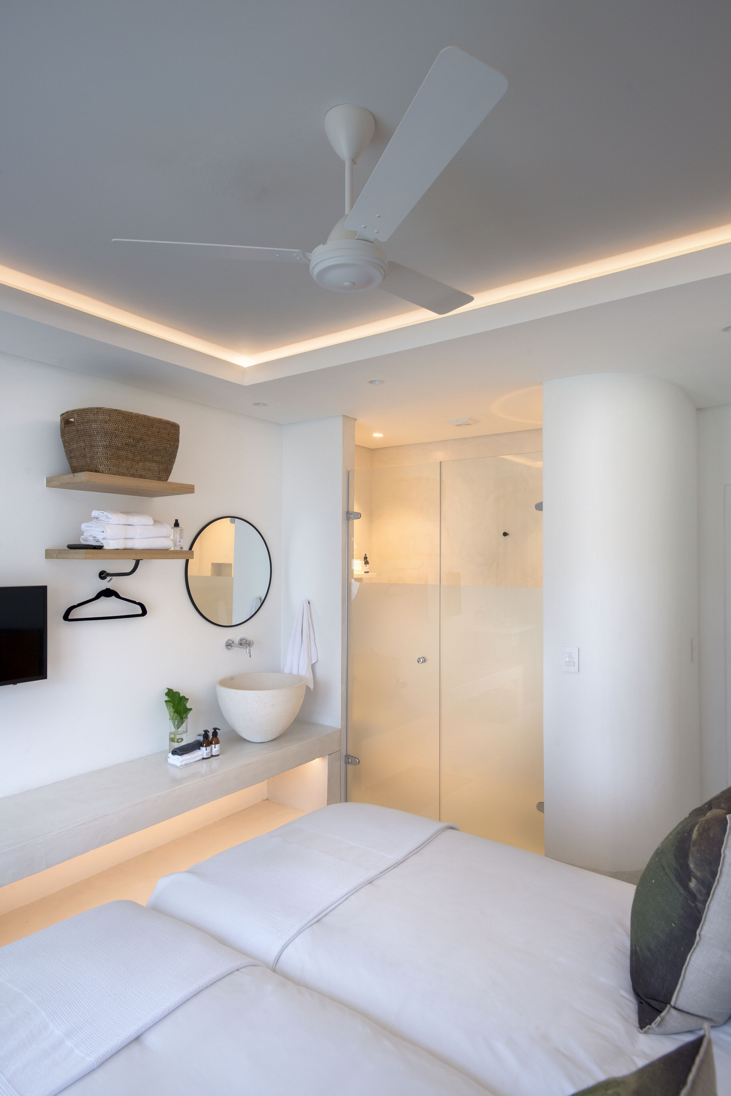Un baño moderno con un espejo grande, un lavabo blanco y un ventilador de techo.