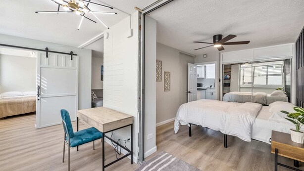 A modern bedroom with a bed, a desk, and a chair. - Modern Condo Near Waikiki Beach & Free Parking (Honolulu)