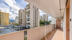 A balcony with a view of high-rise buildings, a clear sky, and a door marked "EXIT". - Modern Condo Near Waikiki Beach & Free Parking (Honolulu)