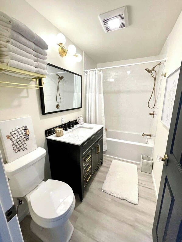 Ein modernes Badezimmer mit Toilette, Waschbecken, Spiegel, Dusche und Badewanne.