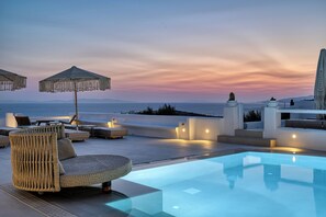 A rooftop pool area with lounge chairs and umbrellas, overlooking a body of water. - Paola Sunset Mykonos (Mykonos)