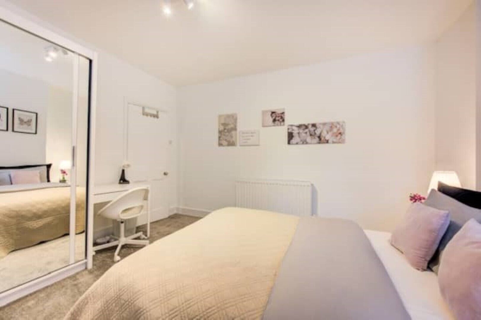 A bedroom with a bed, a desk, and a chair.