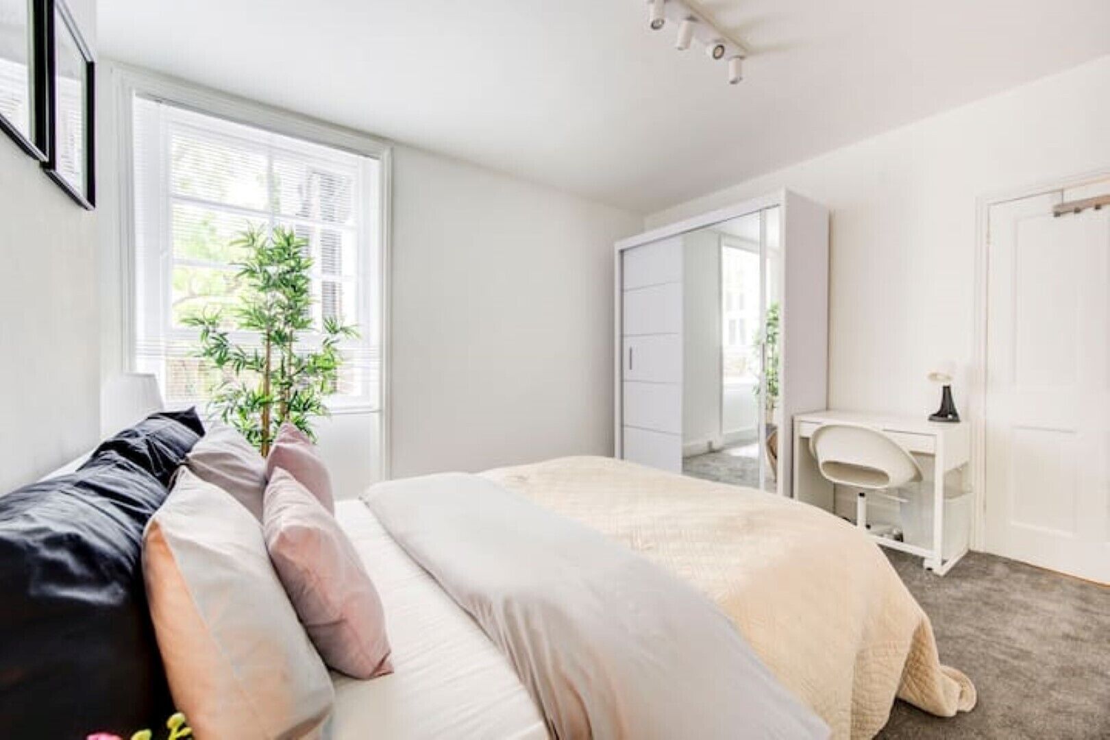 A bedroom with a bed, bedside table, and a wardrobe.