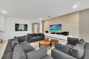 A modern living room with a sectional sofa, a flat-screen TV, and a coffee table.
