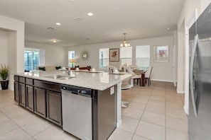 A modern kitchen with a central island, built-in dishwasher, and stainless steel appliances. - Pool Privacy! Value! Resort 8 mi 2 Disney! 1210 (Davenport)