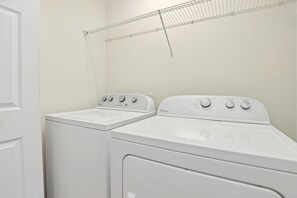 A laundry room with two white Whirlpool washers and dryers. - Pool Privacy! Value! Resort 8 mi 2 Disney! 1210 (Davenport)