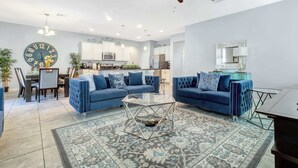Una sala de estar moderna con sofá, mesa de centro y un comedor con sillas y una mesa.