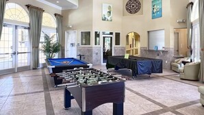 A spacious lobby with a foosball table, comfortable seating, and a pool table.