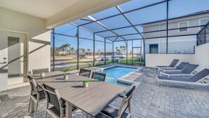 A covered patio with a pool, outdoor seating, and a view of the surrounding area. - Value! Clean! Lazy River-Resort 6 mi 2 Disney! 108 (Davenport)