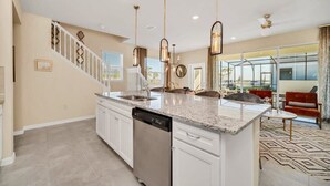 A spacious kitchen with a central island, white cabinetry, and stainless steel appliances. - Value! Clean! Lazy River-Resort 6 mi 2 Disney! 108 (Davenport)