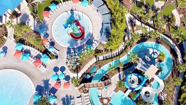 An aerial view of a resort with a central pool, multiple water slides, and sun loungers. - Star Wars | Themed Rooms | Resort Near Disney 2061 (Davenport)