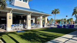 A modern building with a flat roof and a covered patio area with outdoor seating. - Star Wars | Themed Rooms | Resort Near Disney 2061 (Davenport)
