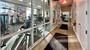 A fitness center with exercise equipment, a ceiling fan, and a sign for the fitness center. - Star Wars | Themed Rooms | Resort Near Disney 2061 (Davenport)