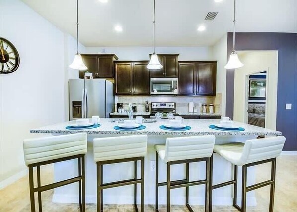 Enjoy cooking in this well-equipped kitchen with a central island and bar stools.