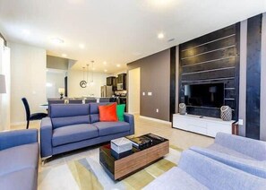 Relax in this stylish living room with a comfortable sofa, coffee table, and large flat-screen TV.