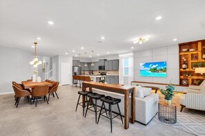 Una cocina moderna con armarios grises, una isla central e iluminación colgante.