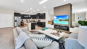 A modern living room with a sofa, coffee table, and a TV mounted on a wooden wall.