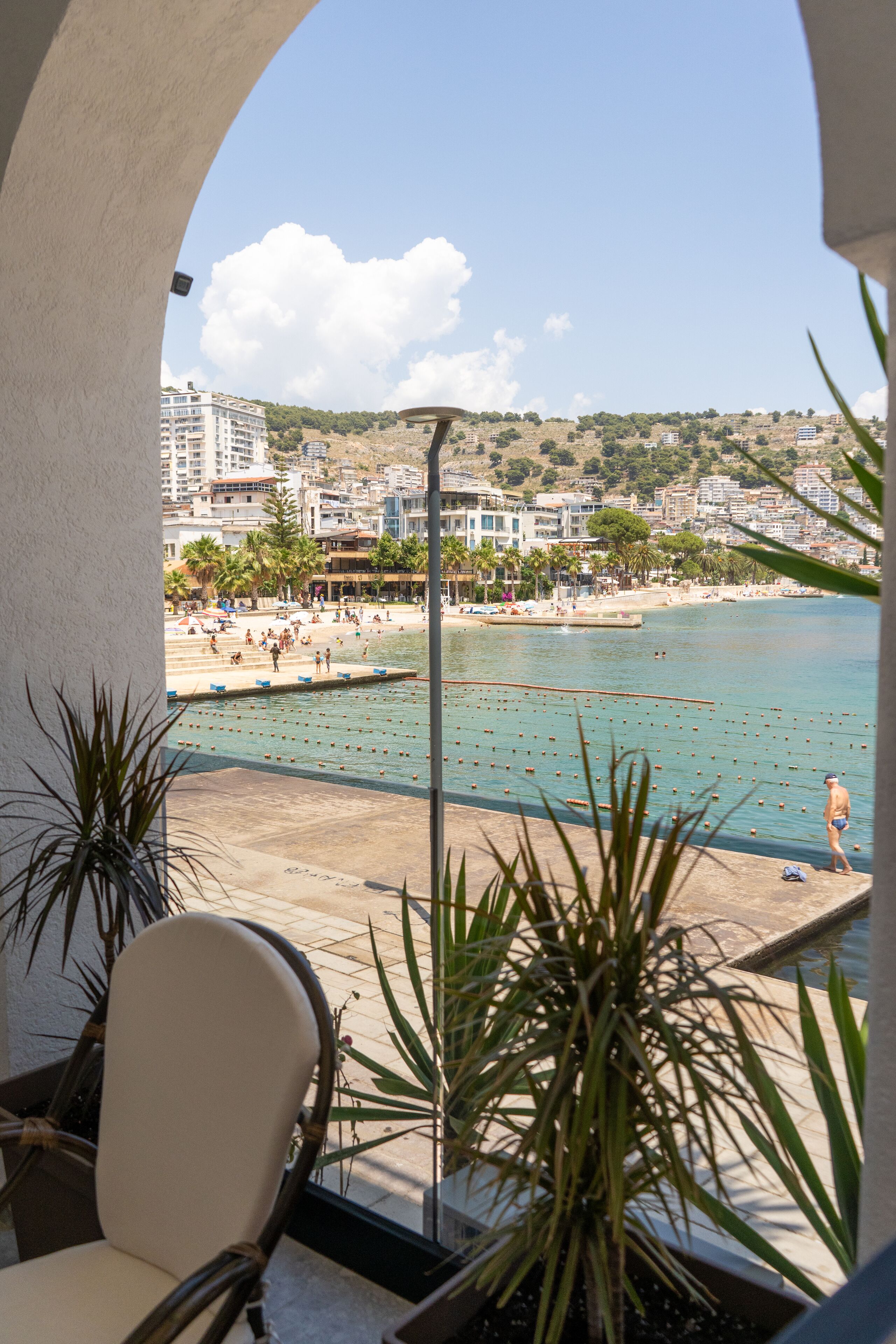 A balcony with a view of a beach and cityscape.