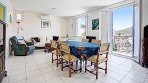 A dining area with a table set for six, surrounded by chairs with patterned upholstery.