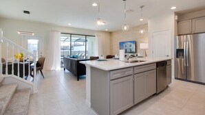 A modern kitchen with stainless steel appliances, a central island, and pendant lighting. - Pool! Family Value! Epic Resort 6 mi 2 Disney-8916 (Kissimmee)