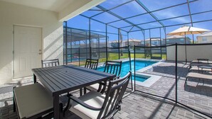 A covered patio with a pool, outdoor furniture, and a view of neighboring houses. - Pool! Family Value! Epic Resort 6 mi 2 Disney-8916 (Kissimmee)