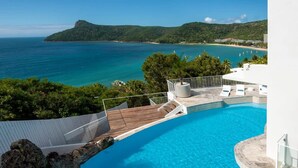 Une piscine avec vue sur la mer et un paysage montagneux.