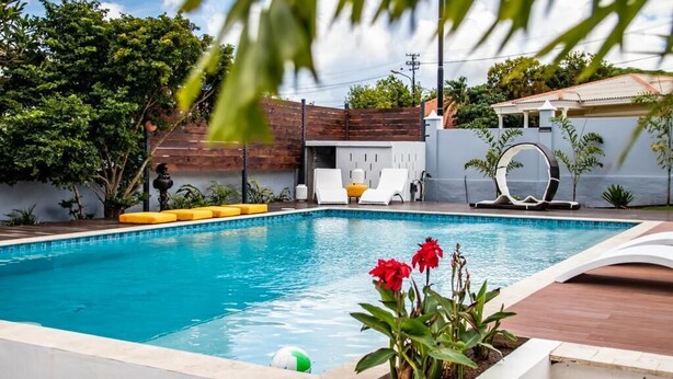 Ein Schwimmbecken mit Liegestühlen und einer Holzterrasse.