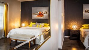 Ein modernes Schlafzimmer mit einem großen Bett, Nachttischen und Bildern an den Wänden.