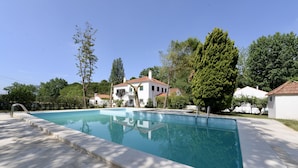 A rectangular swimming pool with a clear blue water surface, surrounded by a concrete deck.