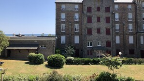 A stone building with multiple windows and a central entrance. - CROMLEC'H - Duplex, Aperçu Mer - DT170 (Carnac)