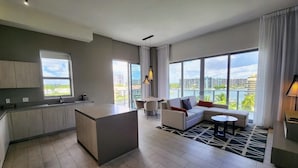 Un apartamento moderno con cocina, comedor y sala de estar. Cuenta con ventanas amplias, vistas de la ciudad y un balcón.