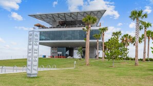 Un edificio moderno con fachada de vidrio y una estructura de techo singular.