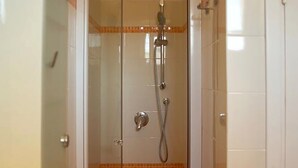 A glass-enclosed shower stall with a handheld showerhead and a drain. - Bright and comfortable, it offers a wonderful view from the sea-facing terrace.  (Viareggio)